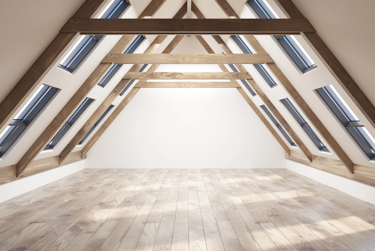 A modern, empty attic with wooden beams, light wood flooring, and multiple skylight windows on both sides. A modern, empty attic with wooden beams, light wood flooring, and multiple skylight windows on both sides.
