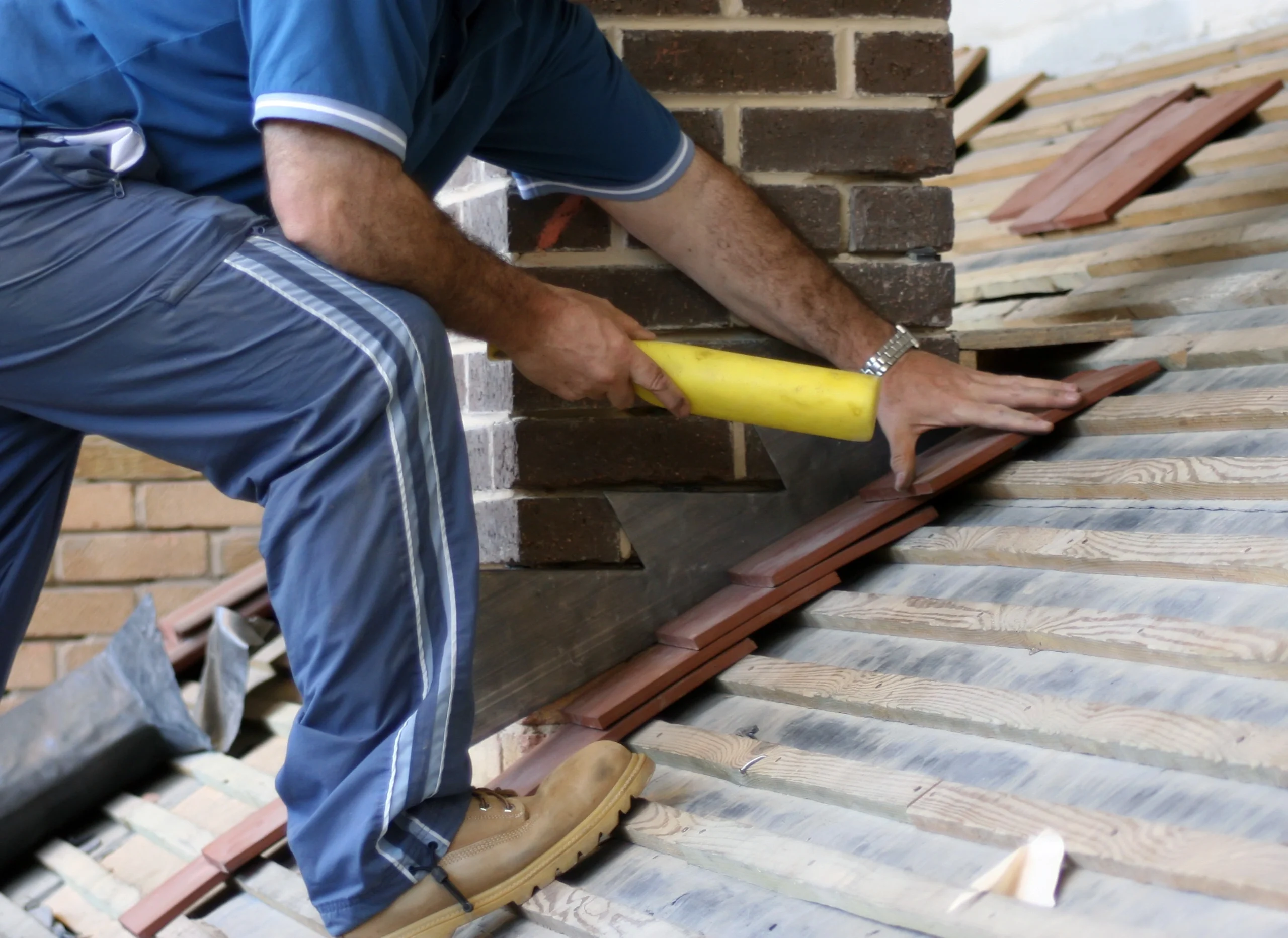 close up to worker repairing roof flashing
