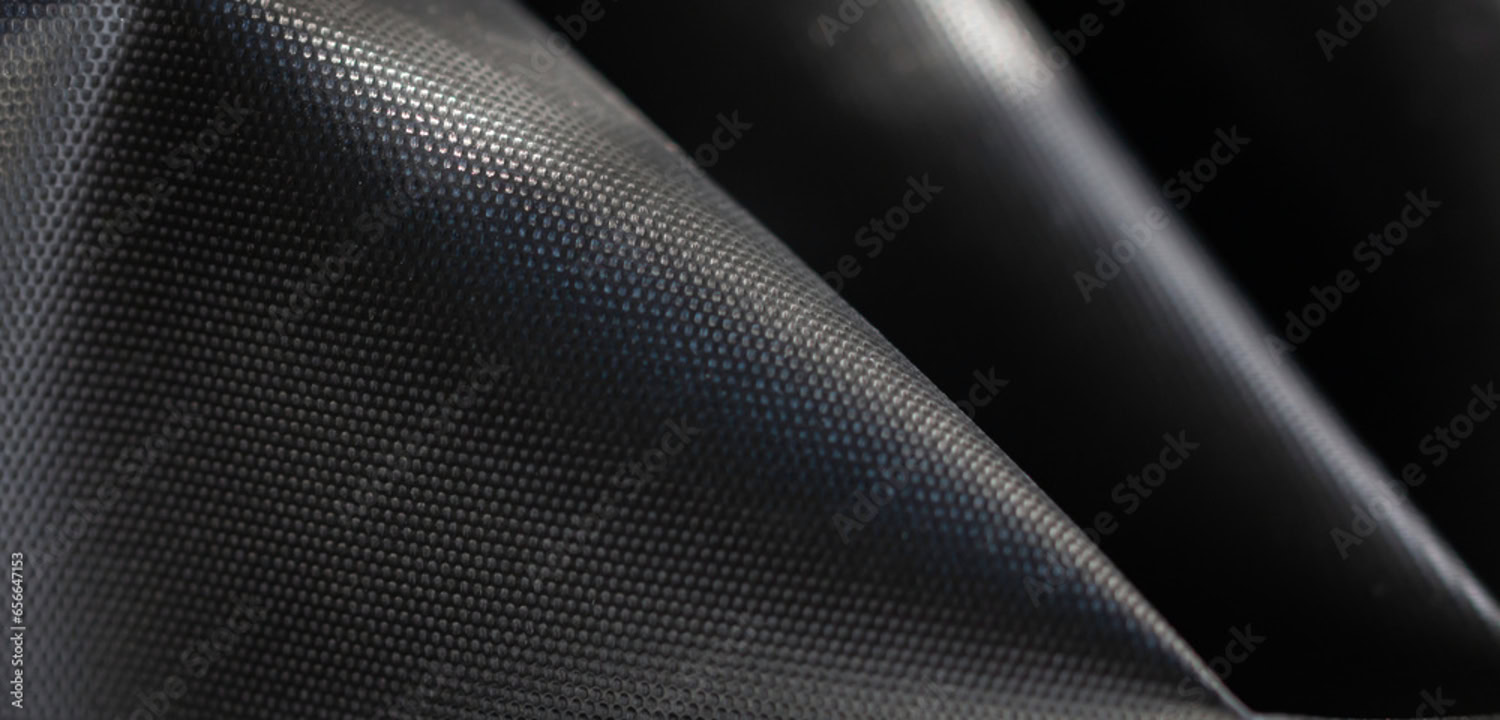 Close-up of a textured, black, pyramid-shaped foam acoustic panel with a grid-like surface pattern. Close-up of a textured, black, pyramid-shaped foam acoustic panel with a grid-like surface pattern.